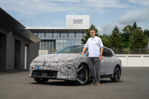 Stephan Hoferer neben dem getarnten Kia EV4