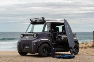 Der Citroën Ami Buggy Rip Curl Vision mit Surfbrett am Strand